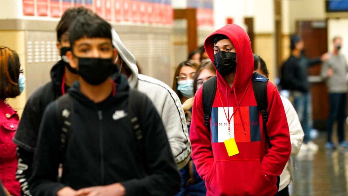 FILE: Students at Wyandotte County High School wear masks as the walk through a hallway on the first day of in-person learning at the school in Kansas City, Kan. 