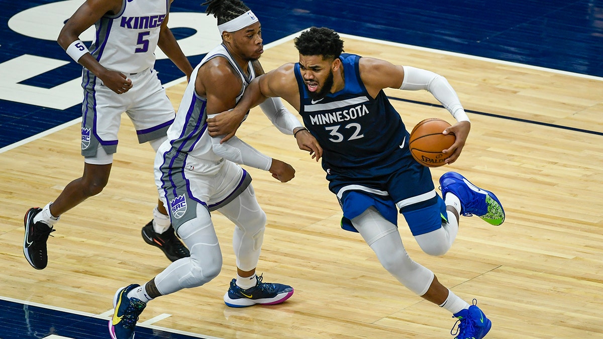 Minnesota Timberwolves center Karl-Anthony Towns (32) is fouled by Sacramento Kings center Richaun Holmes during the first half of an NBA basketball game Monday, April 5, 2021, in Minneapolis. (AP Photo/Craig Lassig)
