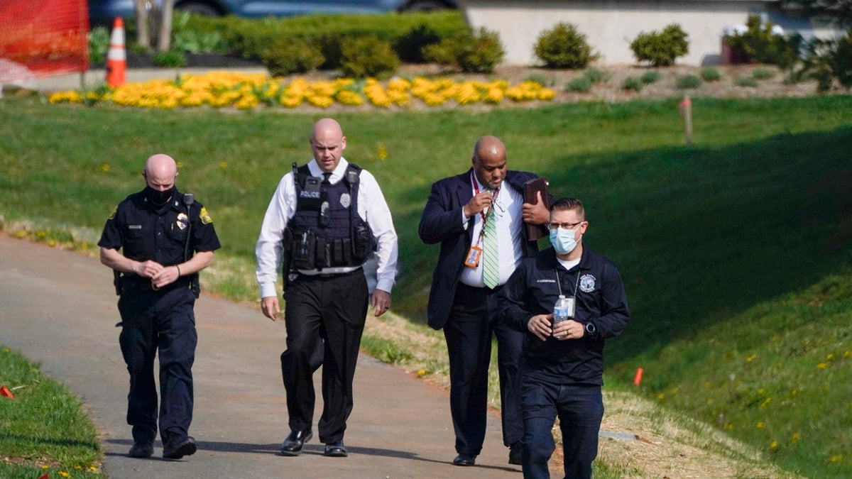 Police walk near the scene of a shooting at a business park in Frederick, Md., Tuesday, April 6, 2021. (AP Photo/Julio Cortez)