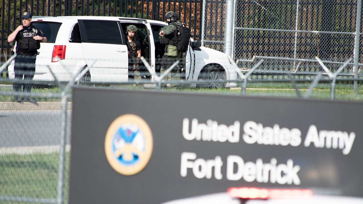 Members of the Frederick Police Department Special Response Team prepare to enter Fort Detrick at the Nallin Farm Gate in a convoy of vans and sedans, following a shooting in the Riverside Tech Park Tuesday morning in Frederick, Md. (Graham Cullen/The Frederick News-Post via AP)