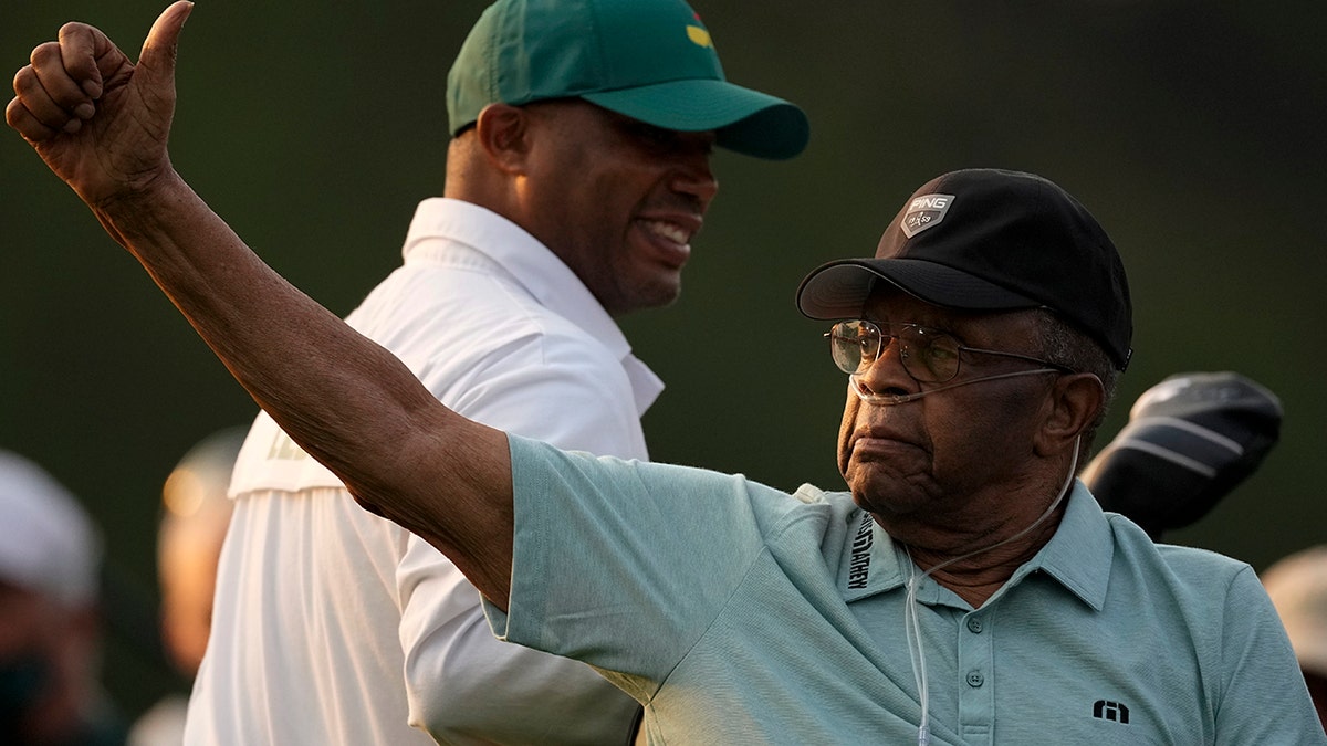 Lee Elder gestures as he arrives for the ceremonial tee shots before the first round of the Masters golf tournament on Thursday, April 8, 2021, in Augusta, Ga.