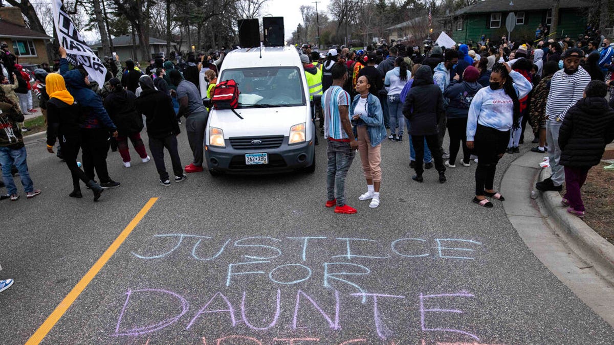 People gather in protest, Sunday, April 11, 2021, in Brooklyn Center, Minn. 