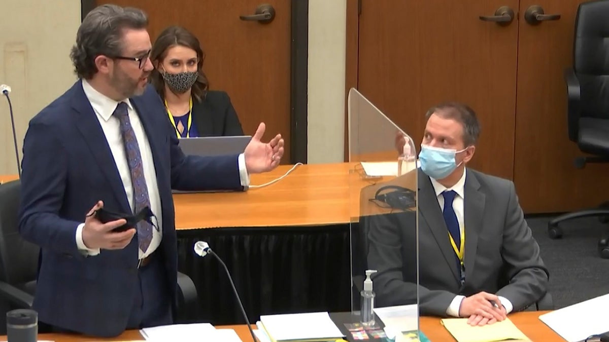 In this image from video, defense attorney Eric Nelson, left, discusses motions before the court as defendant, former Minneapolis police officer Derek Chauvin, right, and Nelson's assistant Amy Voss, back, listen, Monday, April 12, 2021, as Hennepin County Judge Peter Cahill presides over the trial of Chauvin at the Hennepin County Courthouse in Minneapolis. (Court TV, via AP, Pool)