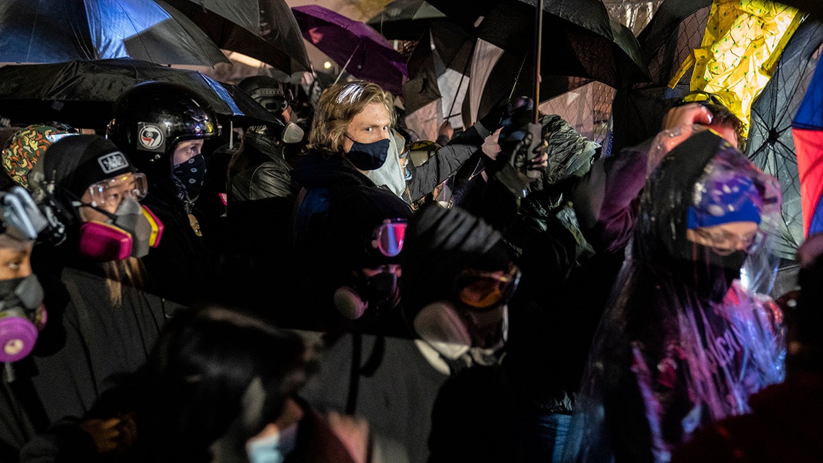 Demonstrators using umbrellas as shields against potential crowd control weapons take part in a protest in response to the fatal shooting of Daunte Wright during a traffic stop, outside the Brooklyn Center (Minn.) Police Department on Thursday, April 15, 2021. (Associated Press)