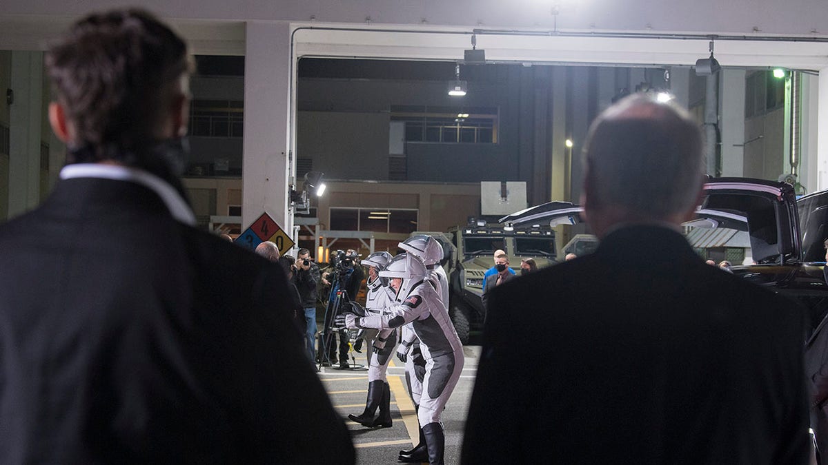 SpaceX Chief Engineer Elon Musk, left, and acting NASA Administrator Steve Jurczyk, right, watch as ESA (European Space Agency) astronaut Thomas Pesquet, Japan Aerospace Exploration Agency (JAXA) astronaut Akihiko Hoshide, and NASA astronauts Shane Kimbrough and Megan McArthur, prepare to depart the Neil A. Armstrong Operations and Checkout Building for Launch Complex 39A to board the SpaceX Crew Dragon spacecraft for the Crew-2 mission launch, Friday, April 23, 2021, at NASA's Kennedy Space Center in Florida. (Aubrey Gemignani/NASA via AP)