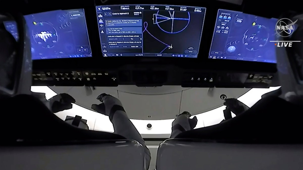 In this image made from NASA TV, the astronauts are seen in the cockpit of the SpaceX Crew Dragon spacecraft as the spacecraft prepares to dock with the international space station, Saturday, April 24, 2021. The recycled SpaceX capsule carrying four astronauts has arrived at the International Space Station, a day after launching from Florida.(NASA via AP)