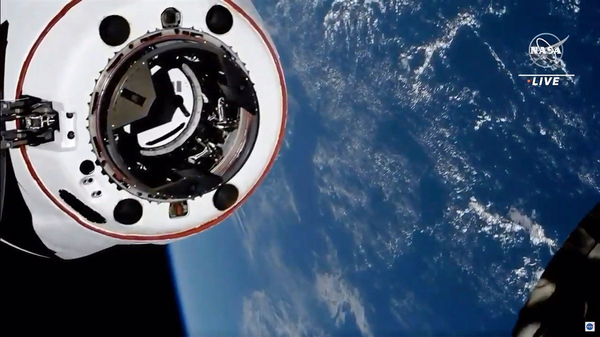 This image made from NASA TV shows the SpaceX Crew Dragon spacecraft, with the Earth behind, approaching the international space station, Saturday, April 24, 2021. The recycled SpaceX capsule carrying four astronauts has arrived at the International Space Station, a day after launching from Florida. (NASA via AP)