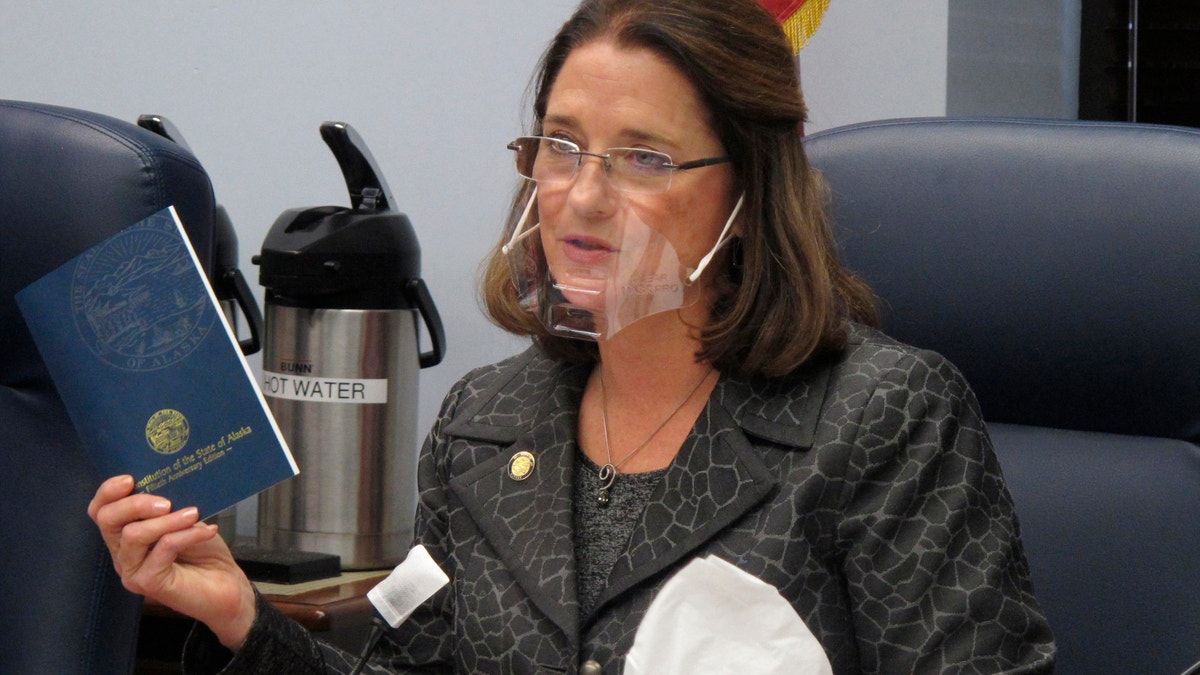 Alaska state Sen. Lora Reinbold, an Eagle River Republican, holds a copy of the Alaska Constitution during a committee hearing in Juneau in this January 2021 photo.