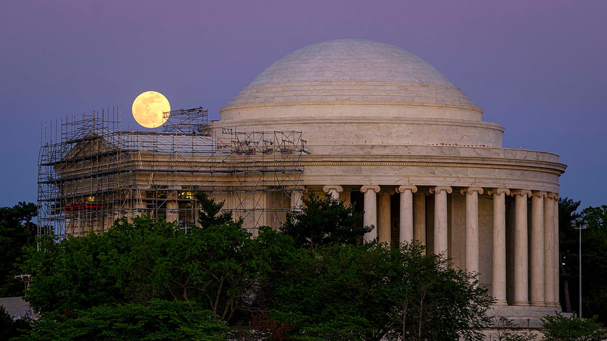 The moon rises over the scaffolding surrounding the entrance to the Jefferson Memorial, in Washington, late Monday, April, 26, 2021. The Jefferson Memorial is in the middle of a multi-year renovation project. (AP Photo/J. David Ake)