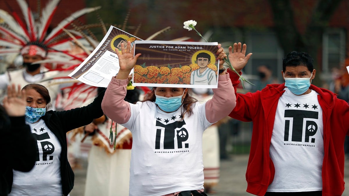 Demonstrators raise their hand as they attend a peace walk honoring the life of Adam Toledo on Sunday in Chicago's Little Village neighborhood. (AP)