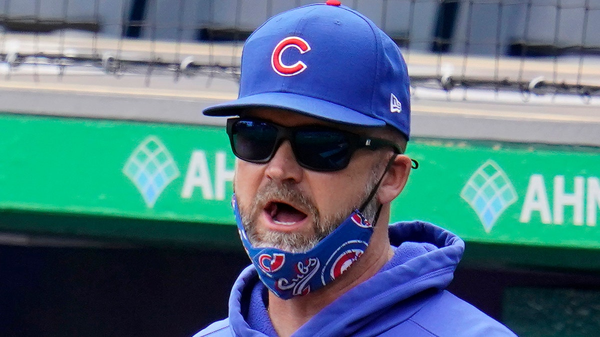 Chicago Cubs manager David Ross stands in the dugout during a baseball game against the Pittsburgh Pirates in Pittsburgh, Sunday, April 11, 2021. (AP Photo/Gene J. Puskar)