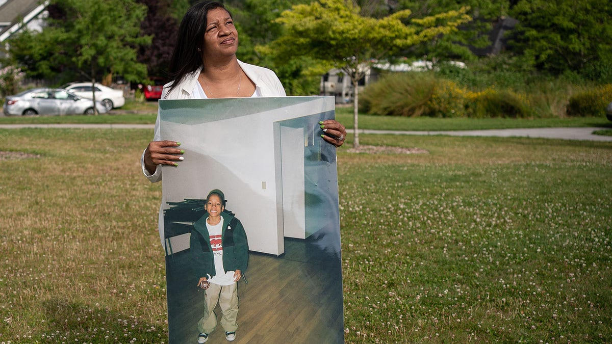 Donnitta Sinclair-Martin, mother of Horace Lorenzo Anderson, poses with a portrait of her son from about 10 years ago during a memorial and rally for peace in memory of Anderson on July 2, 2020 in Seattle.