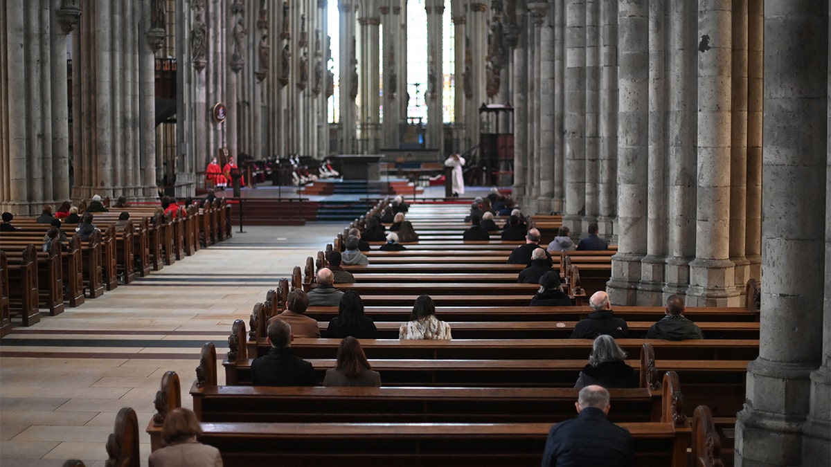 Believers attend a mass held by German Cardinal Woelki on Good Friday at the Cathedral. (Photo by Ina FASSBENDER / AFP) (Photo by INA FASSBENDER/AFP via Getty Images)