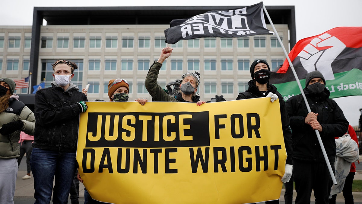 Demonstrators hold a banner in front of the FBI Minneapolis Division building as they march days after Daunte Wright, 20, was shot and killed by former Brooklyn Center Police Officer Kim Potter, in Brooklyn Center, Minnesota, April 13, 2021. 