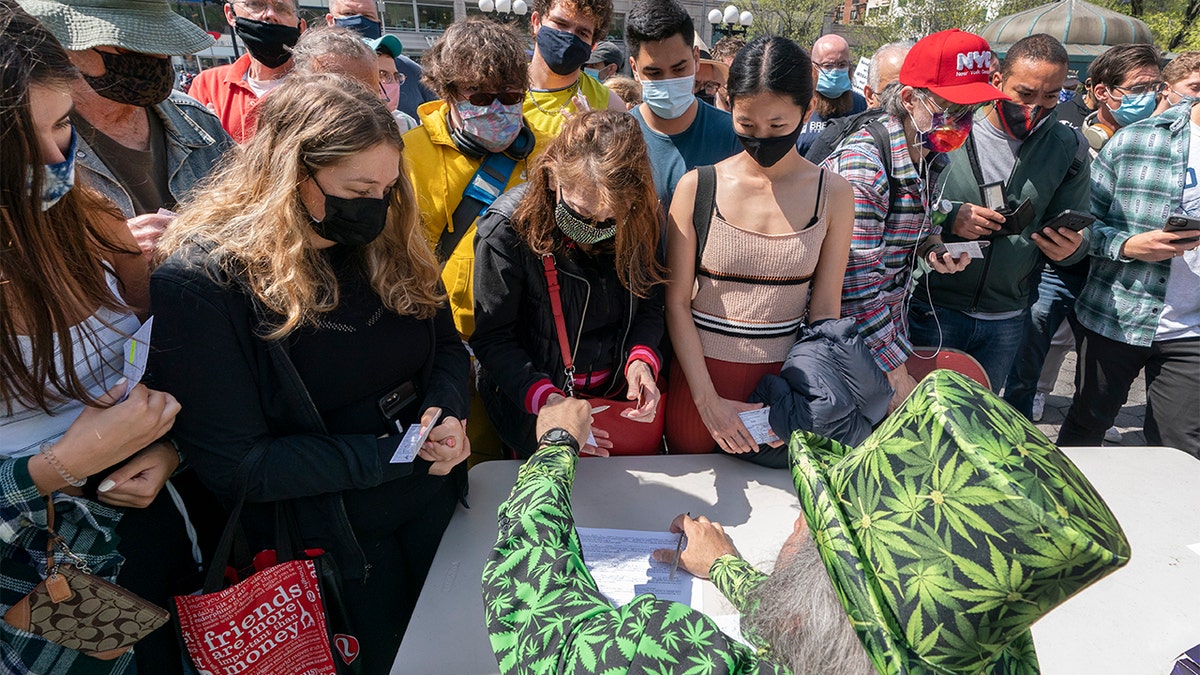 A man wearing a cannabis costume hands out marijuana cigarettes in New York during a "Joints for Jabs" event, where adults who showed their COVID-19 vaccination cards received a free joint. (AP Photo/Mark Lennihan, File)