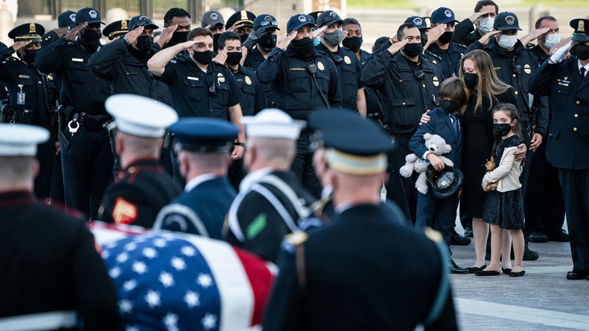 Family members of U.S. Capitol Police Officer William Evans watch as his casket is carried by a joint service honor guard down the East Front steps of the Capitol after lying in honor in the Rotunda on April 13, 2021 in Washington, D.C. Evans was killed and another wounded after a man rammed through security and crashed into a barrier at the complex, forcing it into lockdown less than three months after the mob insurrection at Congress.  