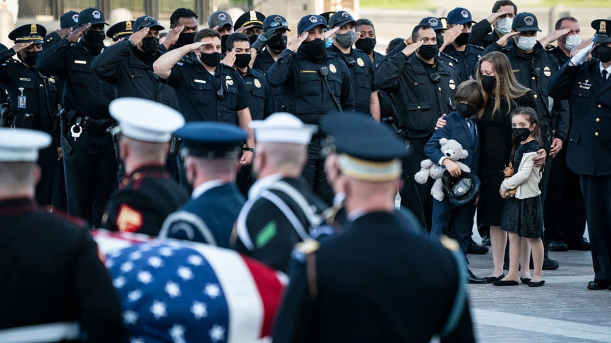 Family members of U.S. Capitol Police Officer William Evans watch as his casket is carried by a joint service honor guard down the East Front steps of the Capitol after lying in honor in the Rotunda on April 13, 2021 in Washington, D.C. Evans was killed and another wounded after a man rammed through security and crashed into a barrier at the complex, forcing it into lockdown less than three months after the mob insurrection at Congress.