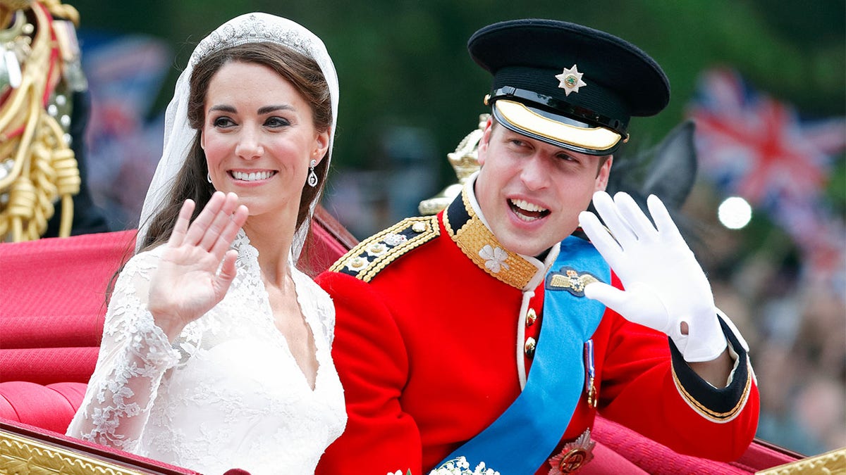 Catherine, Duchess of Cambridge and Prince William, Duke of Cambridge (wearing his red tunic uniform of the Irish Guards, of which he is Colonel) travel down The Mall, on route to Buckingham Palace, in the 1902 State Landau horse-drawn carriage following their wedding ceremony at Westminster Abbey on April 29, 2011, in London, England. The marriage of Prince William, the second in line to the British throne to Catherine Middleton was led by the Archbishop of Canterbury and was attended by 1900 guests, including foreign Royal family members and heads of state. Thousands of well-wishers from around the world have also flocked to London to witness the spectacle and pageantry of the royal wedding.?