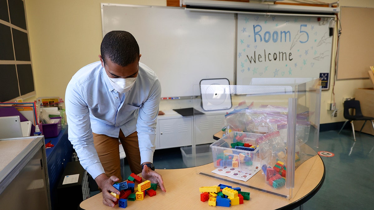 A San Francisco teacher wears a mask in his classroom