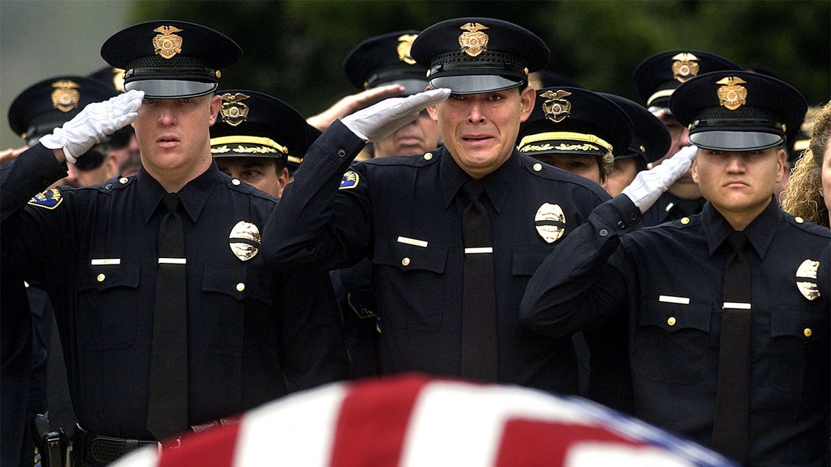 Burbank police officers salute the casket of their slain colleague Matthew Pavelka during funeral services at Forest Lawn Cemetary in Los Angeles Friday. Officer Pavelka was shot and killed while making a routine traffic stop.