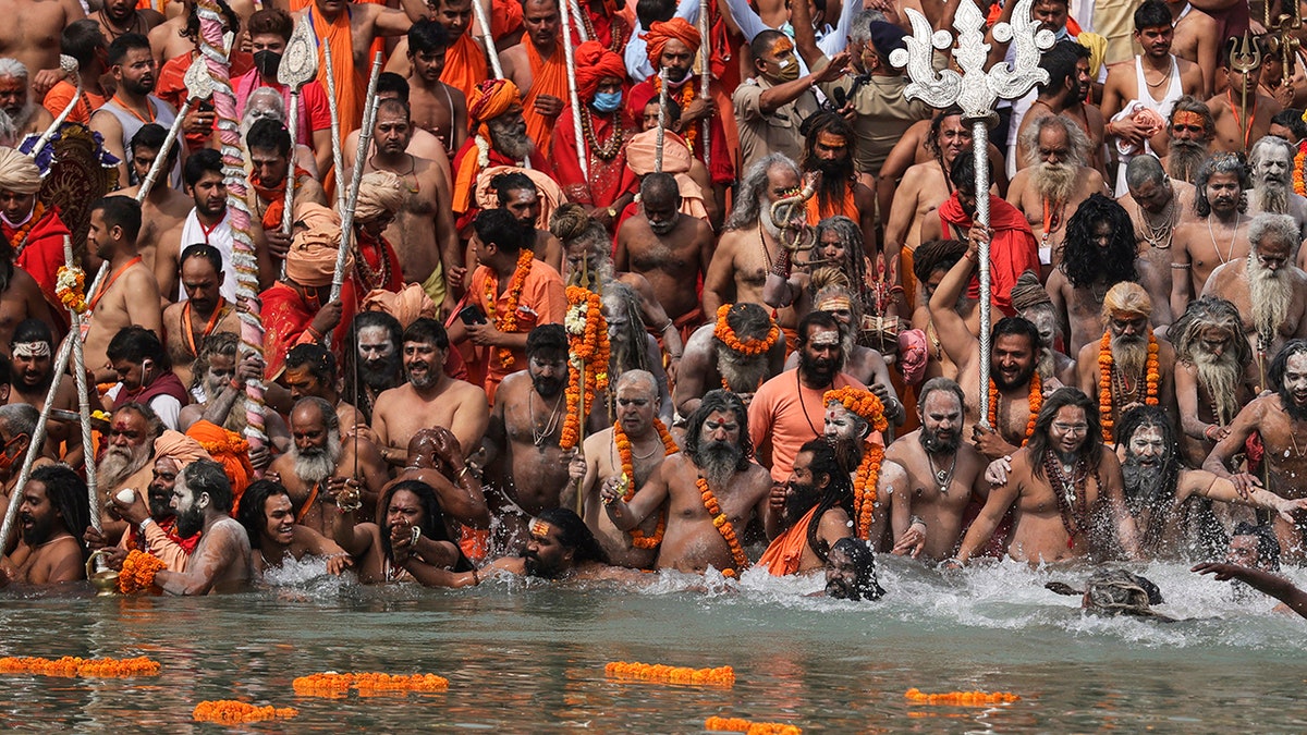 April 12, 2021: Naked Hindu holy men take holy dips in the Ganges River during Kumbh Mela, or pitcher festival, one of the most sacred pilgrimages in Hinduism, in Haridwar, northern state of Uttarakhand, India. 