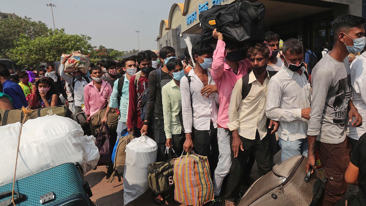 April 14, 2021: People wearing masks as a precaution against the coronavirus stand in queues to board trains at Lokmanya Tilak Terminus in Mumbai.