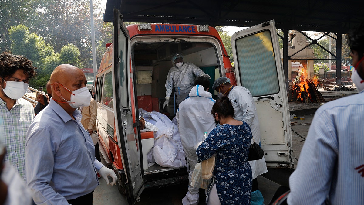 April 19, 2021: Health workers prepare to take out bodies of six victims of COVID-19 from an ambulance for cremation in New Delhi, India.