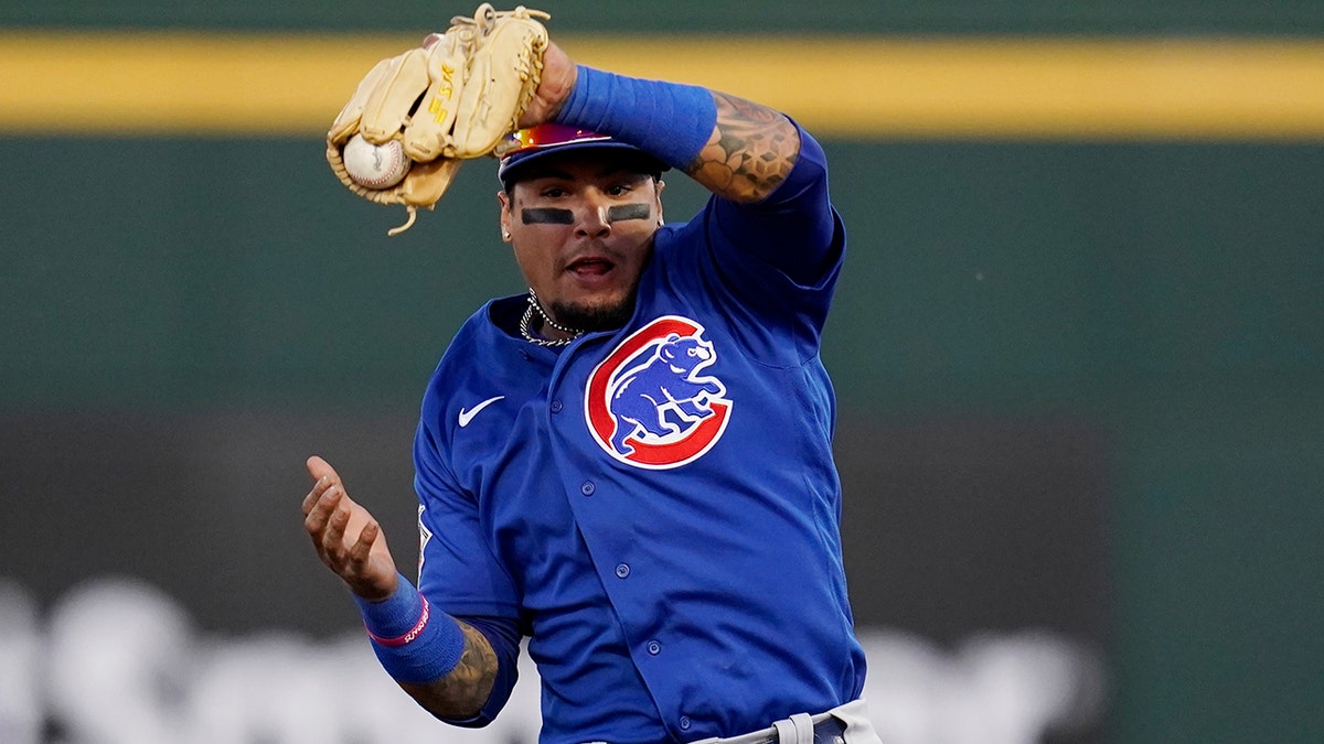 Chicago Cubs shortstop Javier Baez makes a leaping catch on a line drive hit by Cincinnati Reds' Jonathan India during the second inning of a spring training baseball game Saturday, March 27, 2021, in Goodyear, Ariz. (AP Photo/Ross D. Franklin)