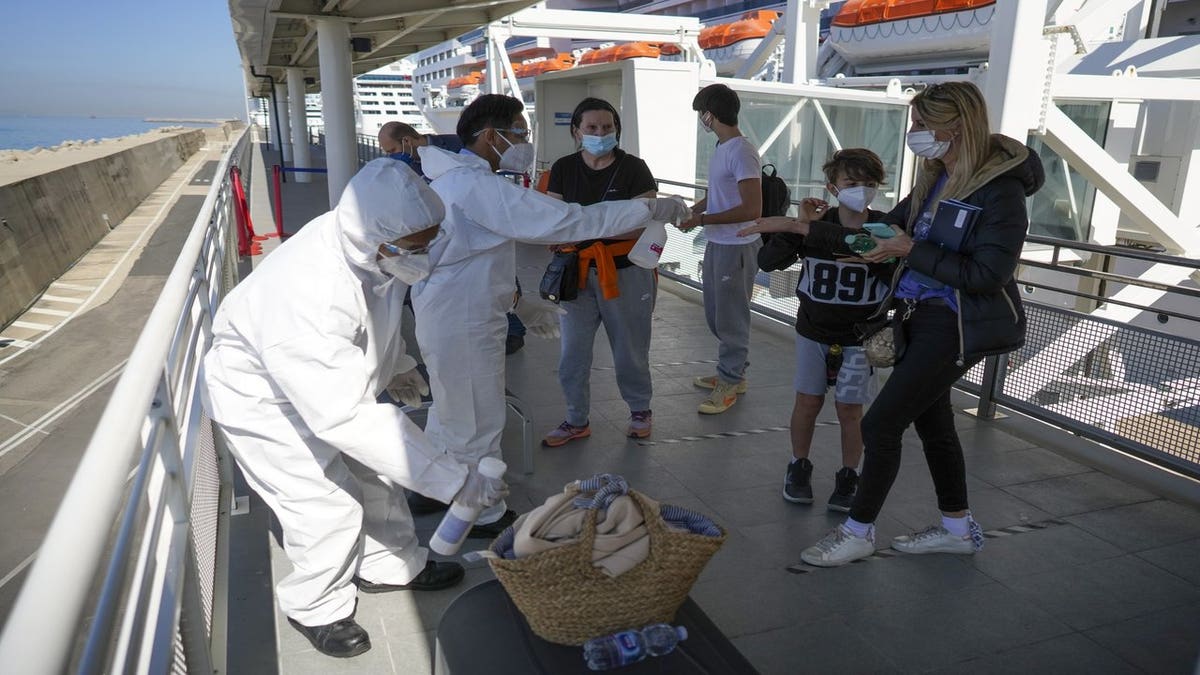 Passengers have their hand luggage sanitized prior to boarding the MSC Grandiosa cruise ship in Civitavecchia, near Rome, Wednesday, March 31, 2021. (AP Photo/Andrew Medichini)