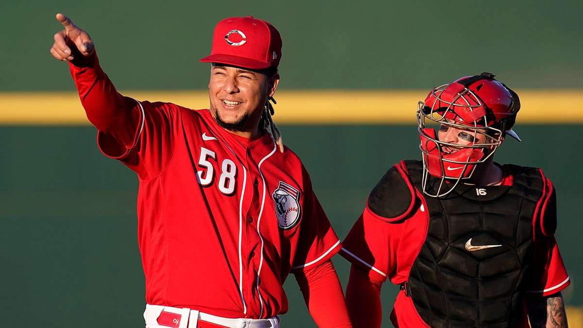 Cincinnati Reds starting pitcher Luis Castillo (58) walks to the dugout with catcher Tucker Barnhart after warming up in the bullpen prior to the team's spring training baseball game against the Chicago Cubs on Saturday, March 27, 2021, in Goodyear, Ariz. (AP Photo/Ross D. Franklin)