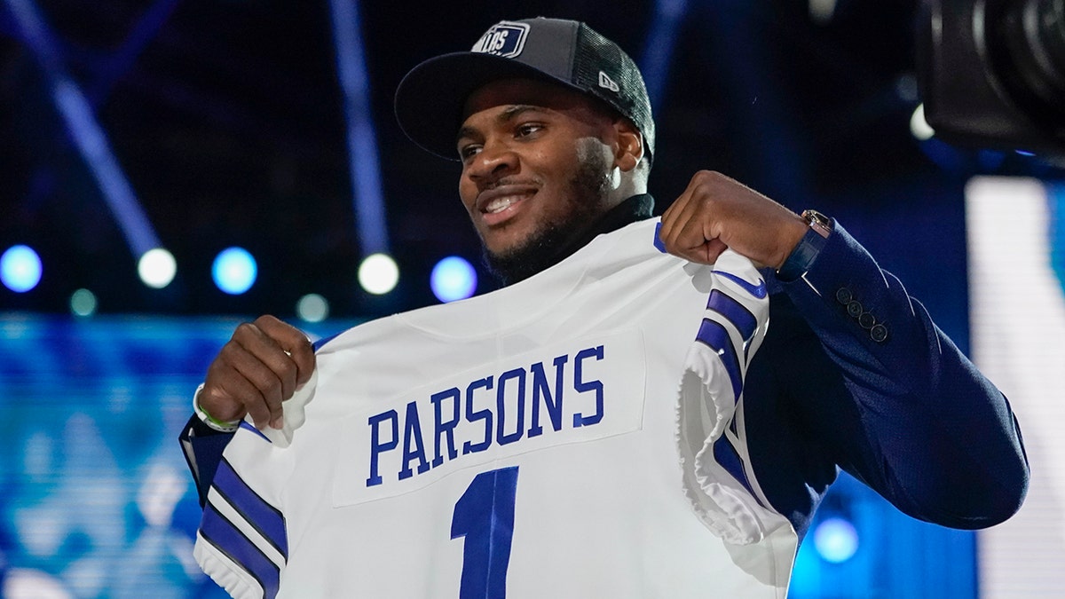 Penn State linebacker Micah Parsons holds a team jersey after the was chosen by the Dallas Cowboys with the 12th pick in the NFL football draft Thursday, April 29, 2021, in Cleveland. (AP Photo/Tony Dejak)
