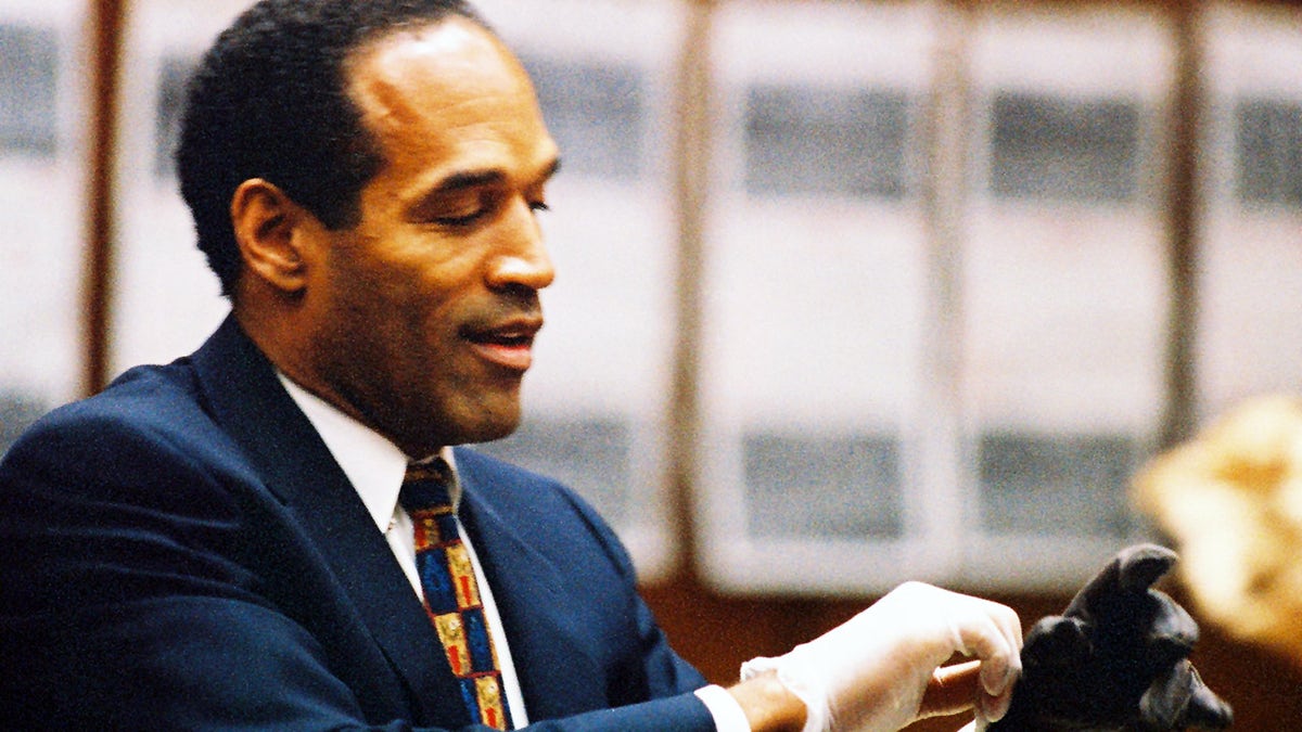 O.J. Simpson tries on a leather glove allegedly used in the murders of Nicole Brown Simpson and Ronald Goldman during testimony in Simpson's murder trial June 15, 1995 in Los Angeles. (Photo by Lee Celano/WireImage)