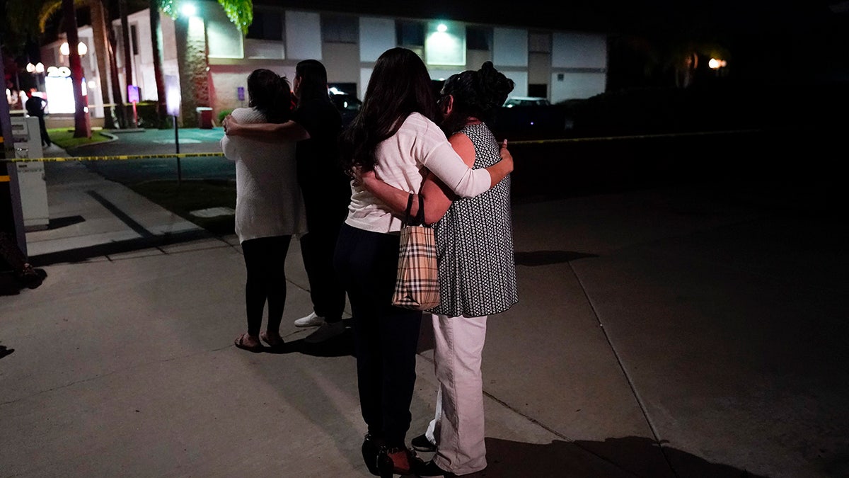 People nearby comforting each other near the shooting scene.