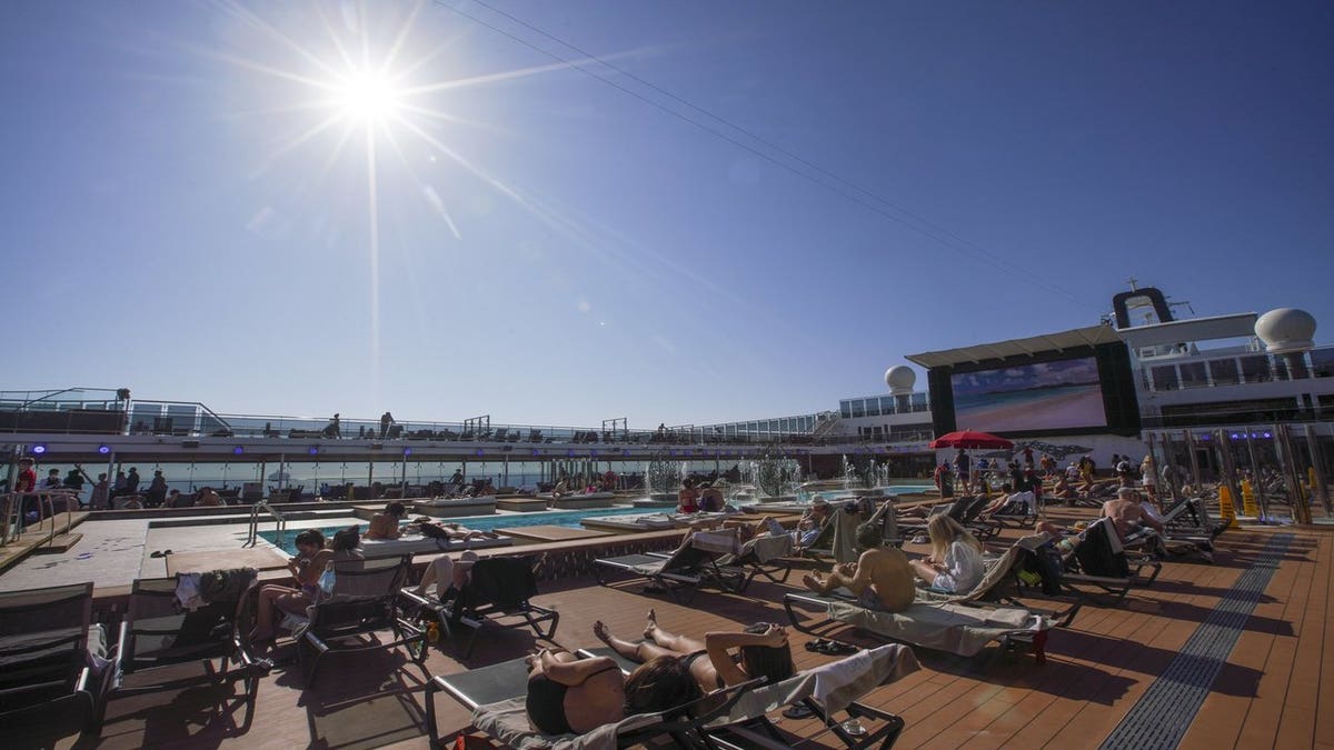 Guests lounge near a pool on the MSC Grandiosa as the rest of Italy is heading back into full lockdown over the Easter weekend, with shops closed and restaurants and bars open for takeout only to try to minimize holiday outbreaks. (AP Photo/Andrew Medichini)