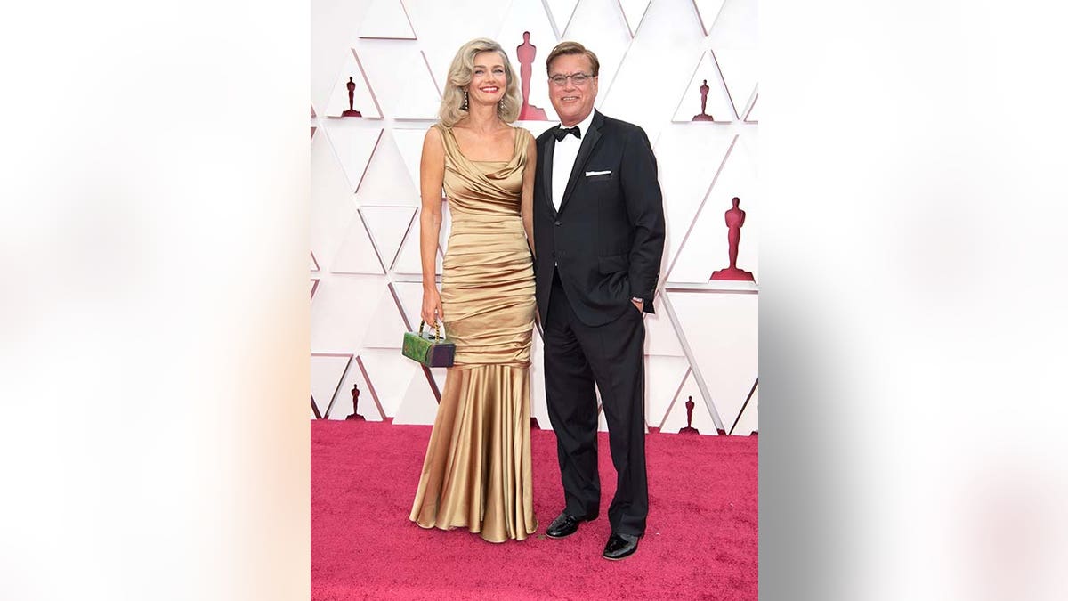 Paulina Porizkova stands with Aaron Sorkin on the Oscars red carpet