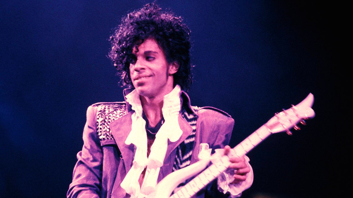Prince playing the guitar on stage