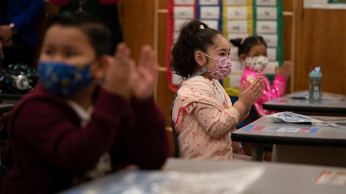 First graders applaud while listening to their teach in a classroom on the first day of in-person learning at Heliotrope Avenue Elementary School in Maywood, California, Tuesday, April 13, 2021. (AP Photo/Jae C. Hong)