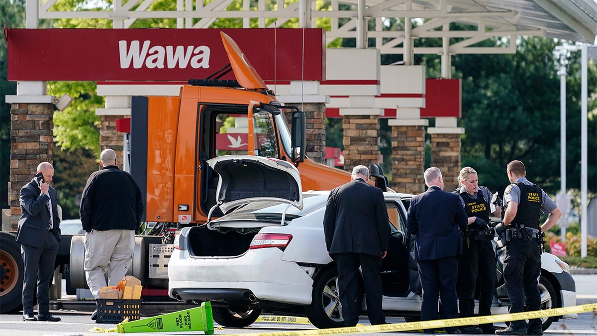 Crime investigators work the scene at a Wawa convenience store and gas station in Breinigsville, Pa., Wednesday, April 21, 2021.  (AP Photo/Matt Rourke)