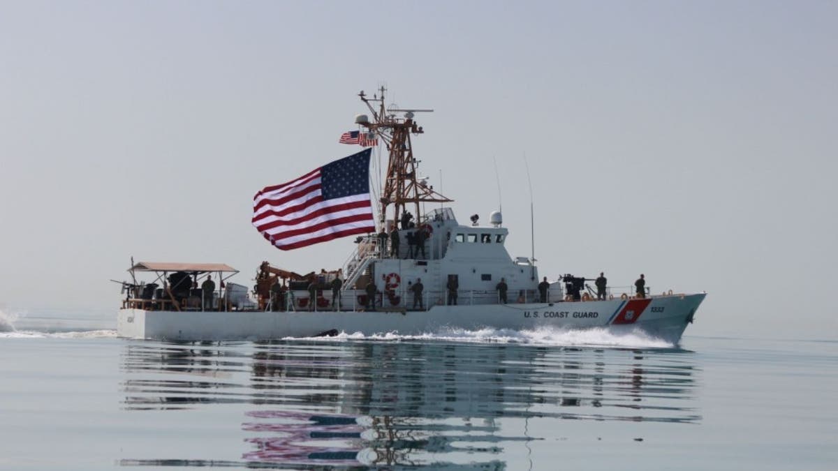 Coast Guardsmen aboard the U.S. Coast Guard cutter USCGC Adak raise the American flag. (U.S. Coast Guard photo by Seaman Frank Iannazzo-Simmons/Released)