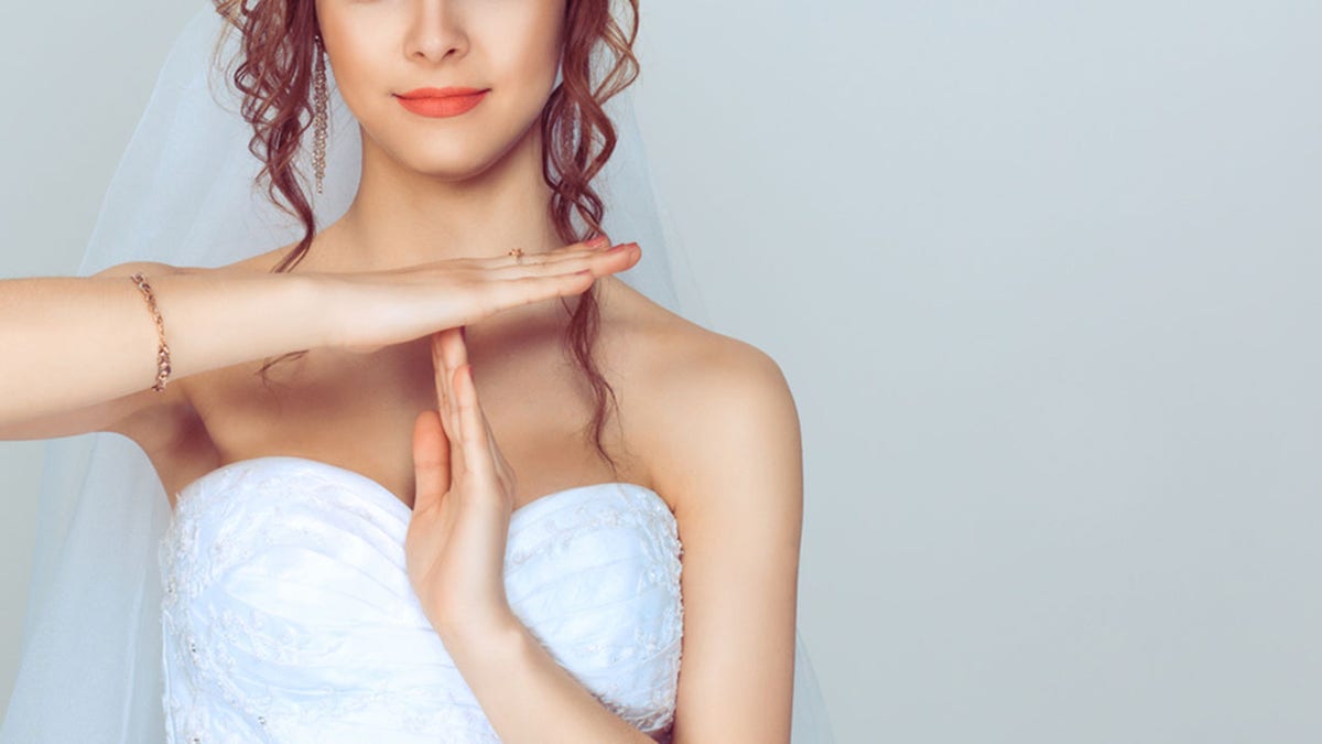 Closeup portrait young bride woman showing time out gesture with hands isolated on light blue