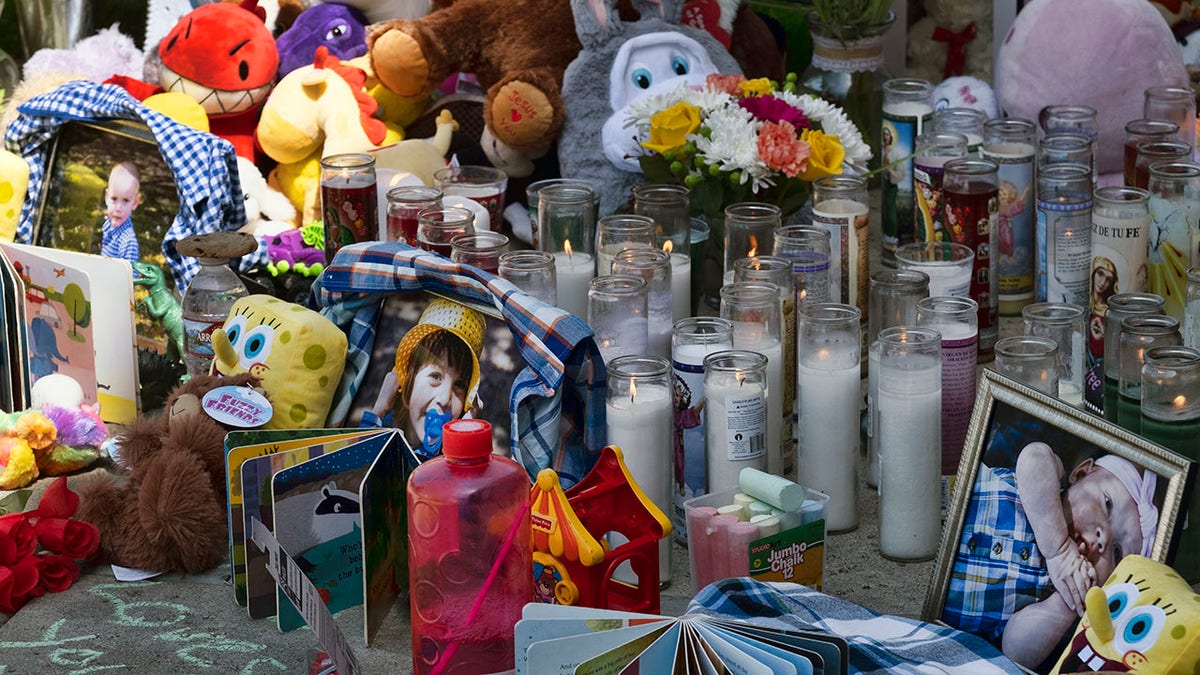 Photos, candles, flowers and balloons are placed as a memorial for three children who were killed at the Royal Villa apartments complex in the Reseda section of Los Angeles, on Monday, April 12, 2021. (AP Photo/Richard Vogel)