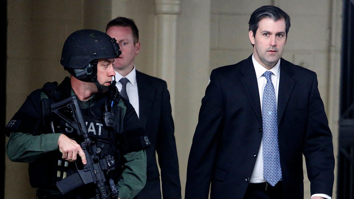 FILE- In this Dec. 5, 2016 file photo, Michael Slager, at right, walks from the Charleston County Courthouse under the protection from the Charleston County Sheriff's Department after a mistrial was declared for his trial in Charleston, S.C. (AP Photo/Mic Smith, File)
