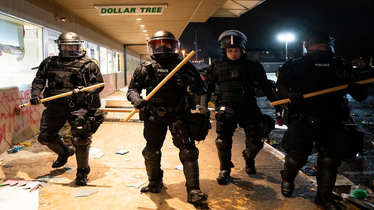 Police clear a strip mall of demonstrators after issuing orders to disperse late Monday in Brooklyn Center, Minn. (AP)