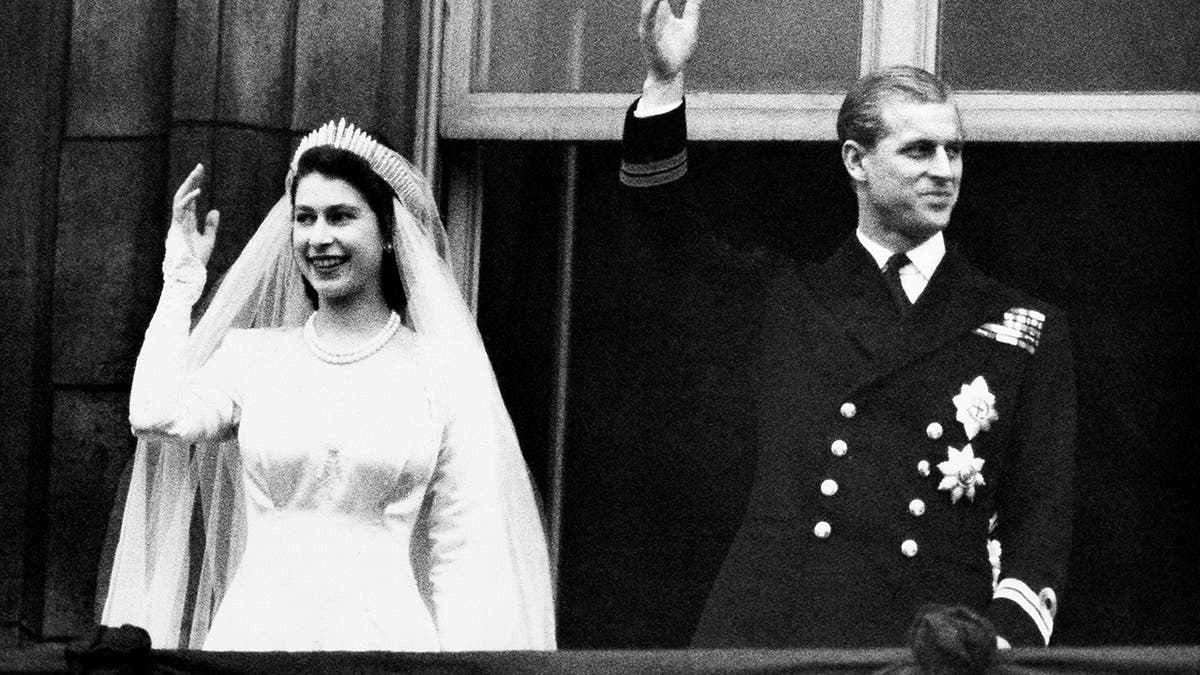 Queen Elizabeth and her husband the Duke of Edinburgh wave to the crowds on their wedding day, from the balcony of Buckingham Palace in London. 