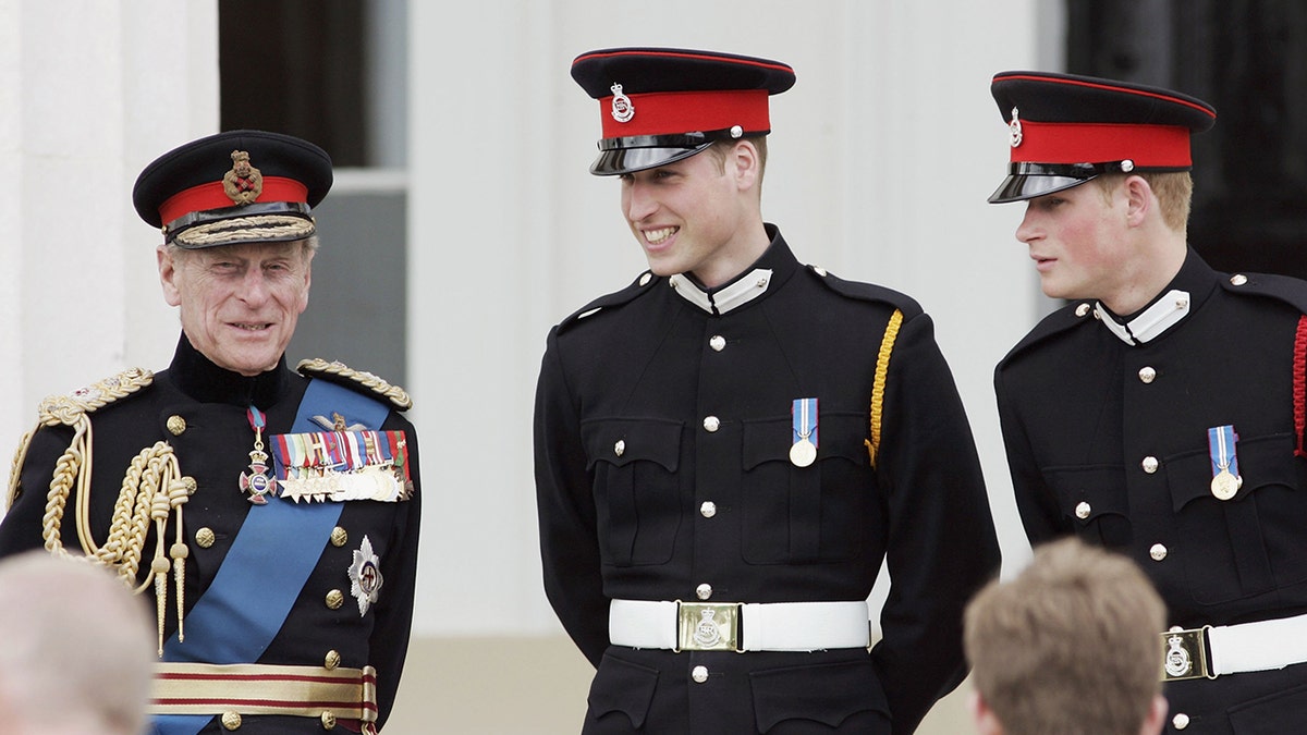 Prince William (C) and Prince Harry (R) chat to their grandfather, Prince Philip, Duke of Edinburgh (L) on the steps of the Old College after the Sovereign's Parade at Sandhurst Military Academy on April 12, 2006 in Surrey, England.
