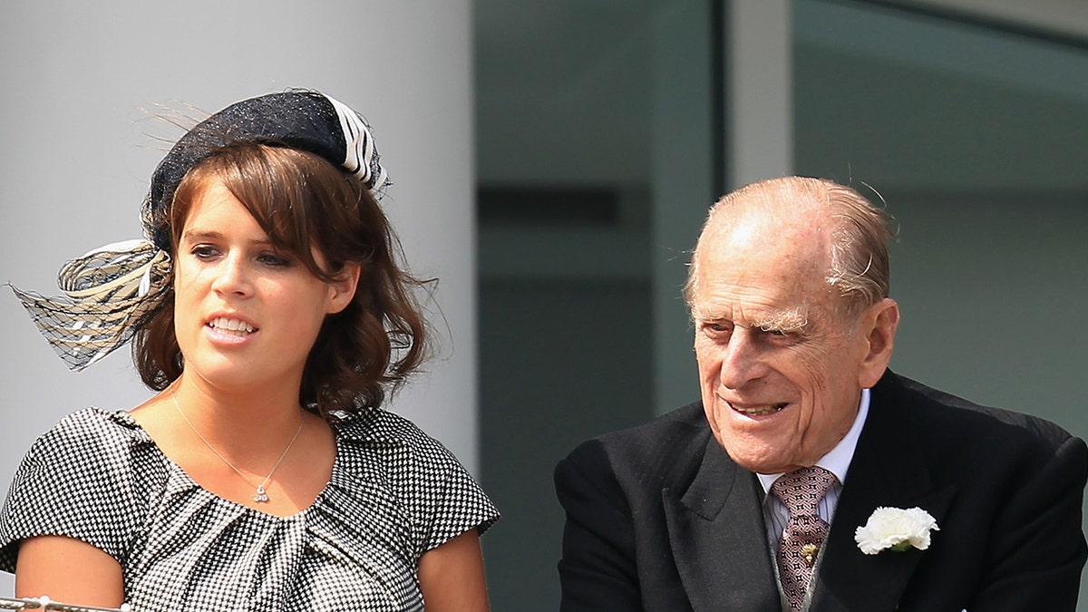 Princess Beatrice of York (L), Princess Eugenie of York (C) and Prince Philip, Duke of Edinburgh (R) watch the action from the royal balcony during the Investec Derby, at the start of the weekend marking the Queen's Diamond Jubilee celebrations, at Epsom Racecourse on June 2, 2012 in Epsom, England.