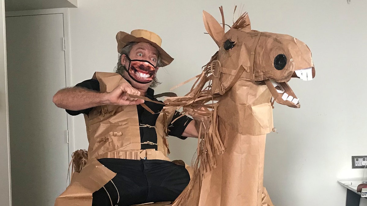 Marriott poses with his paper horse Russell, which he made out of an ironing board, a lamp and brown paper bags. (David Marriott via AP)