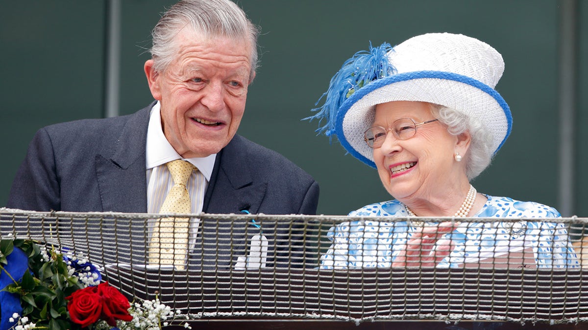 Sir Michael Oswald and Queen Elizabeth II watch the racing from the balcony of the Royal Box as they attend Derby Day during the Investec Derby Festival at Epsom Racecourse on June 4, 2016 in Epsom, England. 