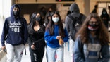 White Plains High School students walk between classes on April 22 in White Plains, N.Y. (AP)