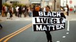 A protester carries a Black Lives Matter flag shortly before the start of a dawn to dusk curfew following the killing of Andrew Brown Jr. by sheriffs last week, in Elizabeth City, North Carolina, U.S. April 27, 2021. REUTERS/Jonathan Drake
